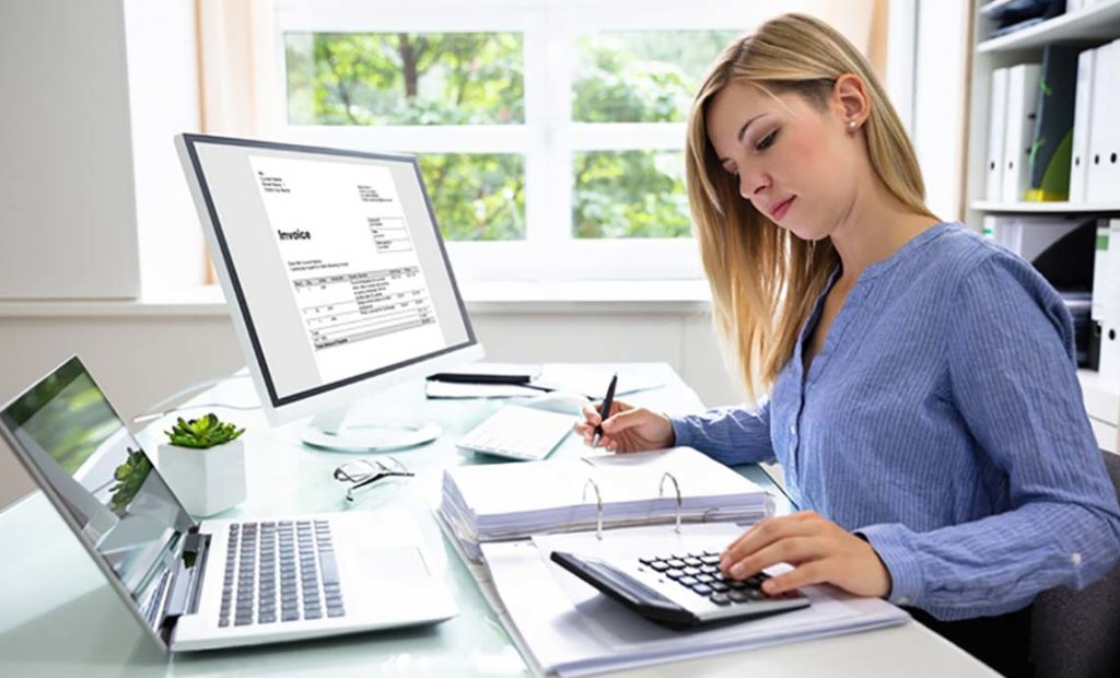 Woman at her desk with her laptop and calculator