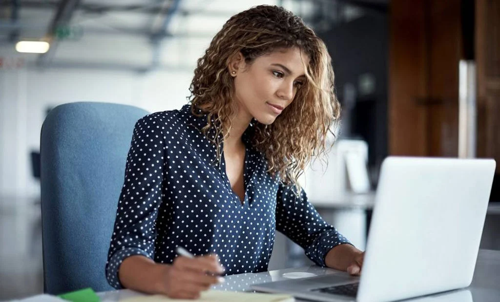 Woman on her laptop looking at MIP Cloud.